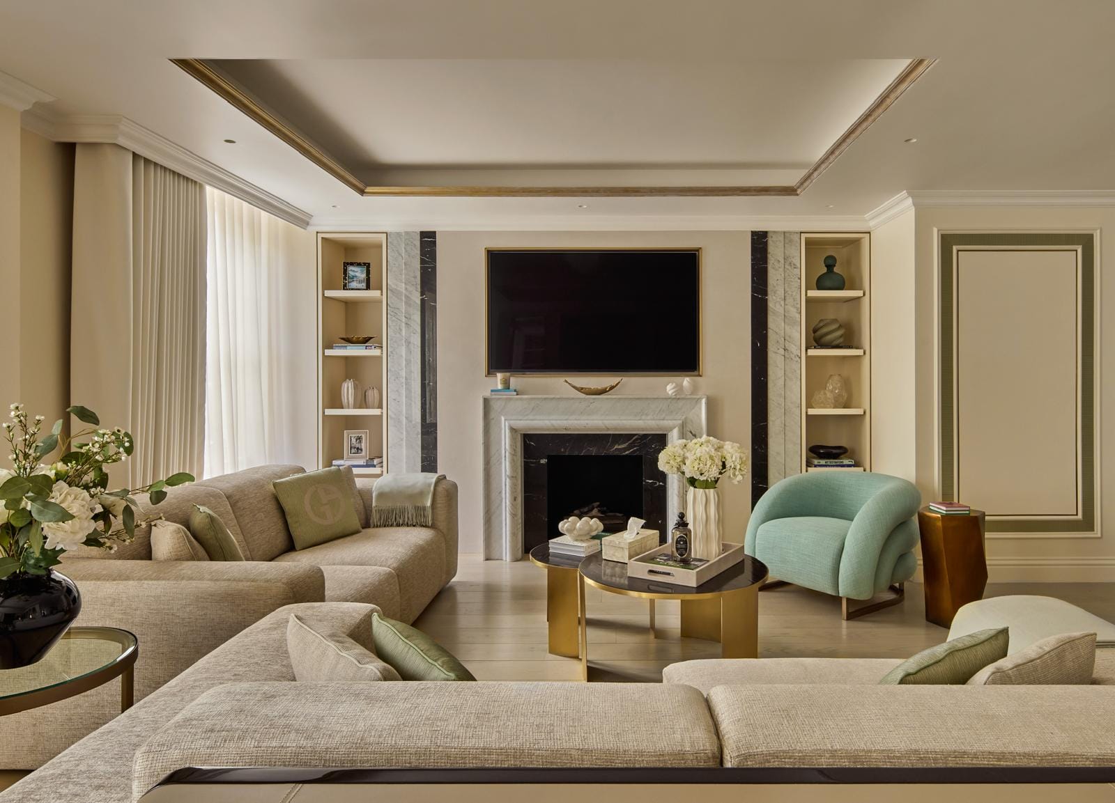 Living room with a marble fireplace, integrated joinery and a soft sage armchair.