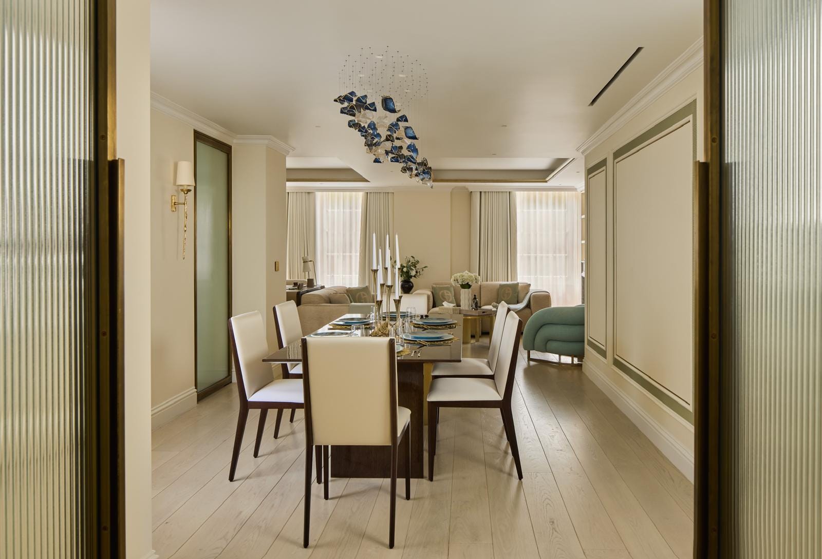 Formal dining room set beneath a blue-and-gold glass ceiling installation.