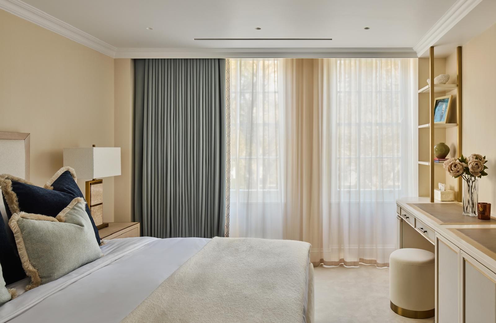 Principal bedroom with floor-length drapery and a built-in vanity nook.