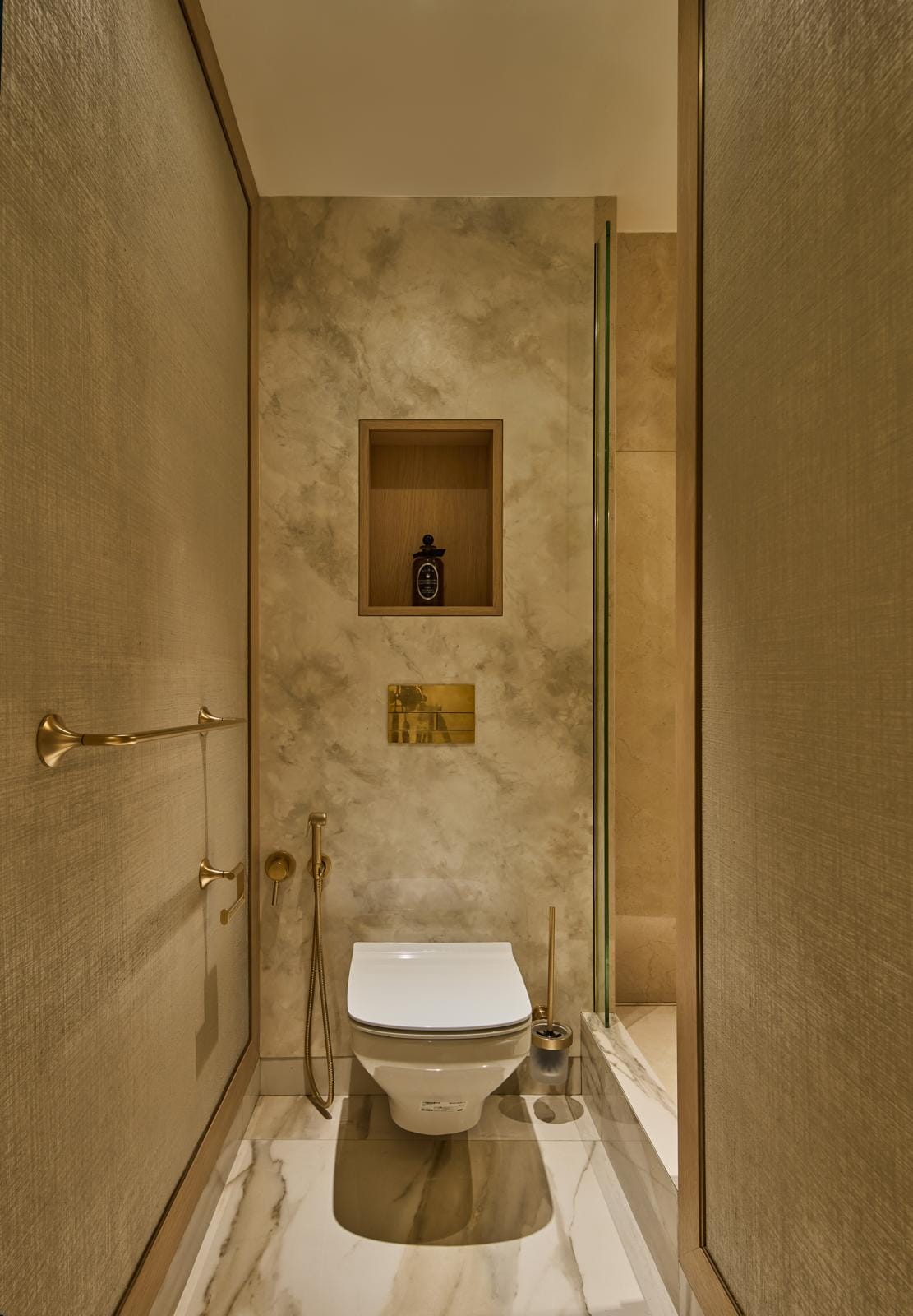 Cloakroom with textured walls, marble detailing and brushed-brass fittings.